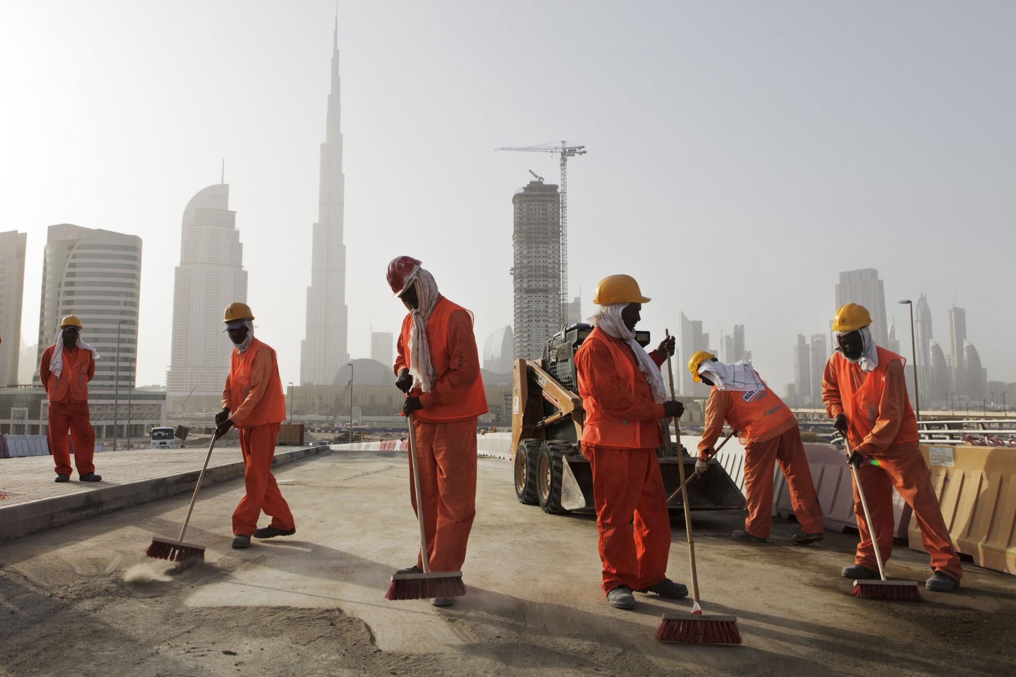 Uae service. Стройка Абу Даби. Рабочие на стройке. Строители в Дубае. Трудовые мигранты в ОАЭ.